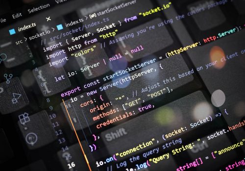 Close-up of colorful TypeScript code for server and socket connection overlayed on a computer keyboard. Perfect for web developers, programmers, tech blogs, coding, and software development content.