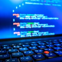 Abstract web developer background. Blue laptop screen with PHP code close up